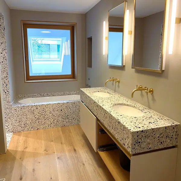 Luxuriöses Badezimmer mit Terrazzofliesen an der Wand und Badewanne